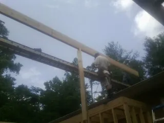 Carpenter setting a ridge beam over a new addition frame — Ice Dam Removal by Roofing Brothers in East Flat Rock