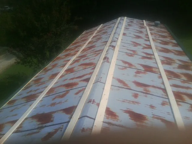 Rusted metal roof panels with new wood purlins before replacement — Storm Damage Roof Repair in East Flat Rock by Roofing Brothers