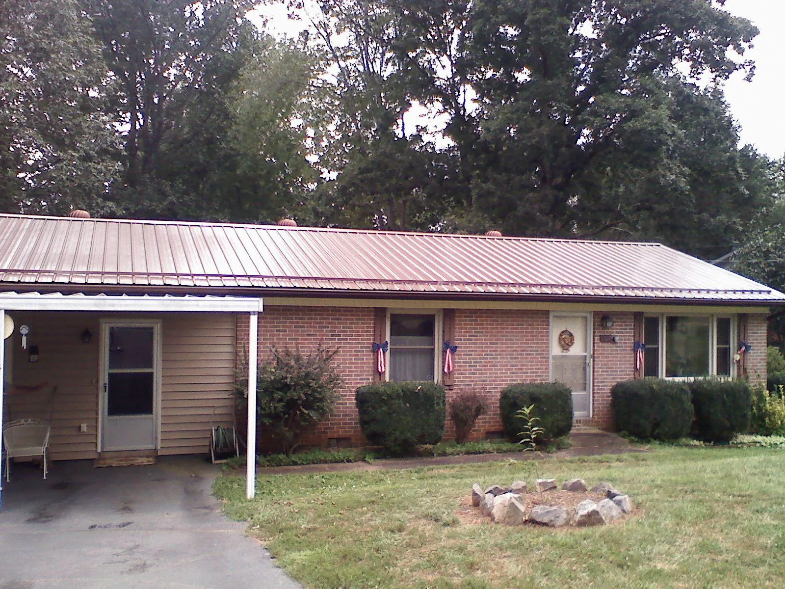 Bronze metal roof and carport on a brick ranch home — Roof Repair work by our crew in East Flat Rock