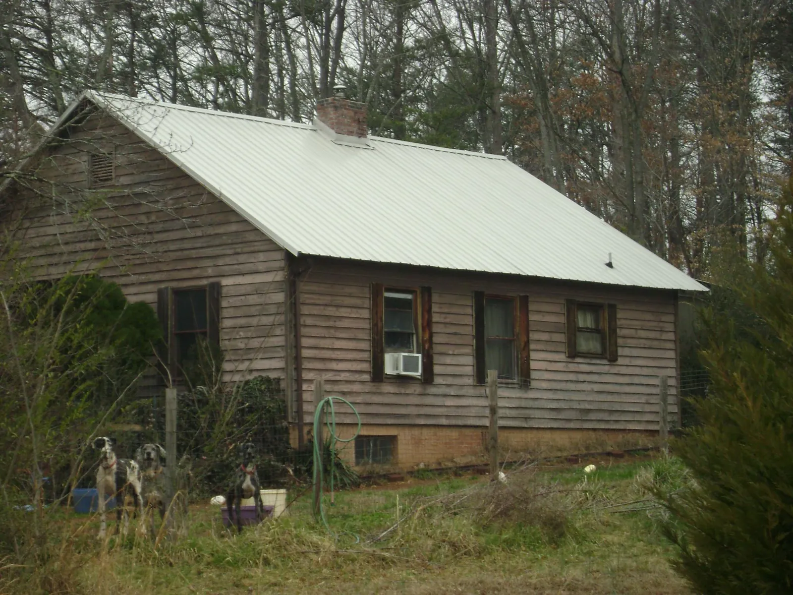 White metal roof on an old wood sided farmhouse, from a Metal Roof Installation job in East Flat Rock